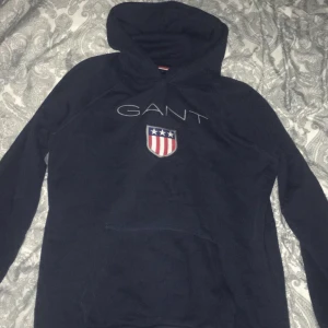  - Marinblå hoodie från GANT, använd 1 gång. Tröjans storlek motsvarar en XS och är i fint skick.