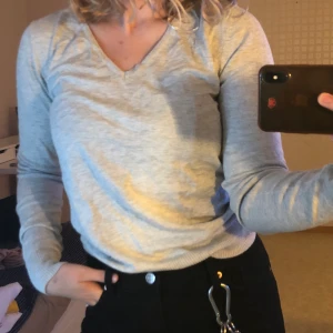 V-Ringad tröja - En gråa långärmad tröja med en v-neck. Denna tröja har endast varit buren 5 gånger och är i väldigt bra skick. Frakten ingår inte i priset!