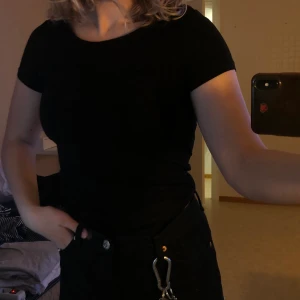 Tajt hel svart t-shirt  - En tajt helsvart t-shirt från h&m. Har aldrig burit den här tröjan och är därmed i väldigt bra skick. Frakten ingår inte i priset!