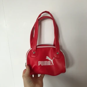 Väska - Så söt väska från puma fyndad second hand. Inga defekter. Bra skick. Man får plats med allt det viktigaste. Säljer då den inte kommer till användning. Skriv privat vid intresse! Frakt tillkommer