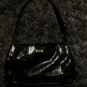 Svart glansig väska  - En super fin och stilren väska. Den är väldigt rak i formerna vilket gör den otroligt stilig. Skriv för mer bilder och priset går att diskutera 