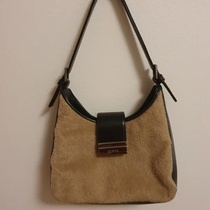 Väska från guess - Väskan är från guess. Den är inte använd av mig en ända gång. Den har brunt päls imitations liknande material och läder? Budgivningen börjar på 100kr o slutar på fredag.