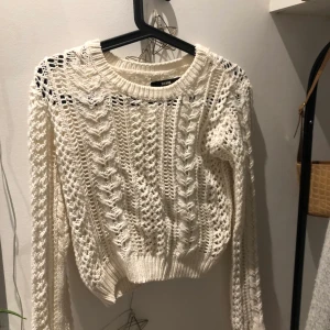 Stickad tröja - Stickad tröja som slutar vid byxan ungefär