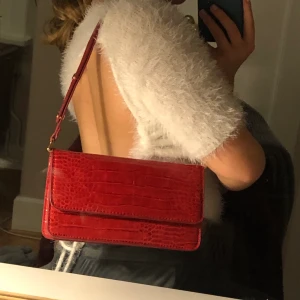 Röd ormskinnsväska - Jättefin röd väska i ormskinn! Nästan lador använd, jätterea och som nyskick! Väldigt rymlig