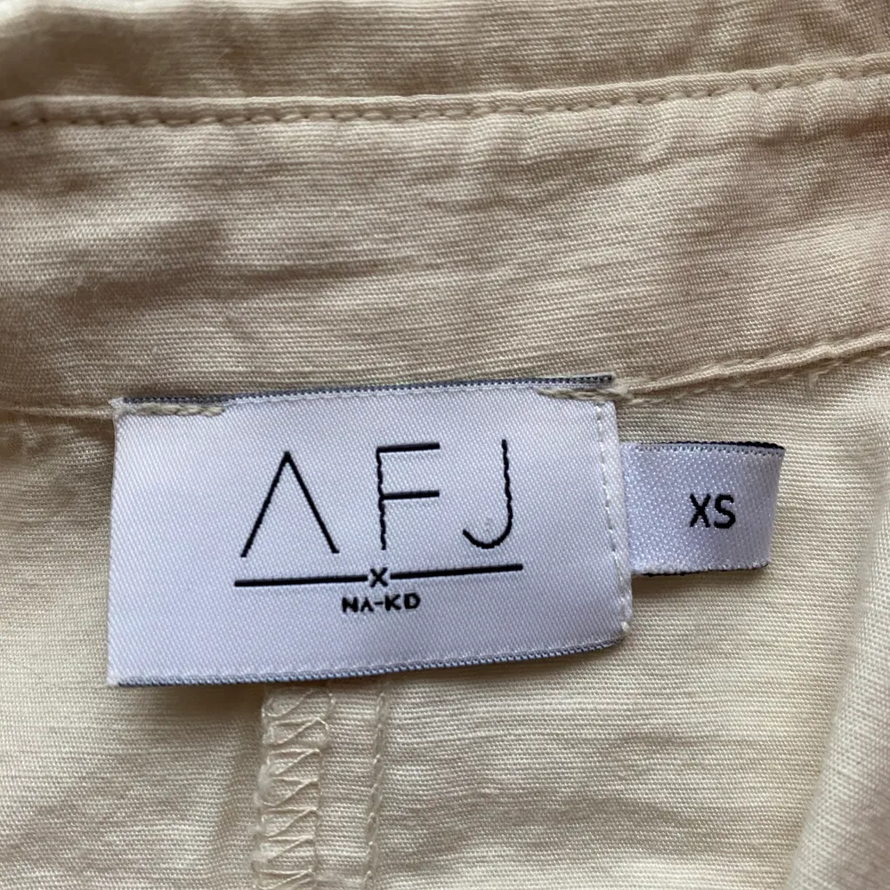 Beige/vit skjortklänning från NA-KD, storlek XS men sitter som en S. Kollektionen är AFJ. Använd en gång🤍. Klänningar.