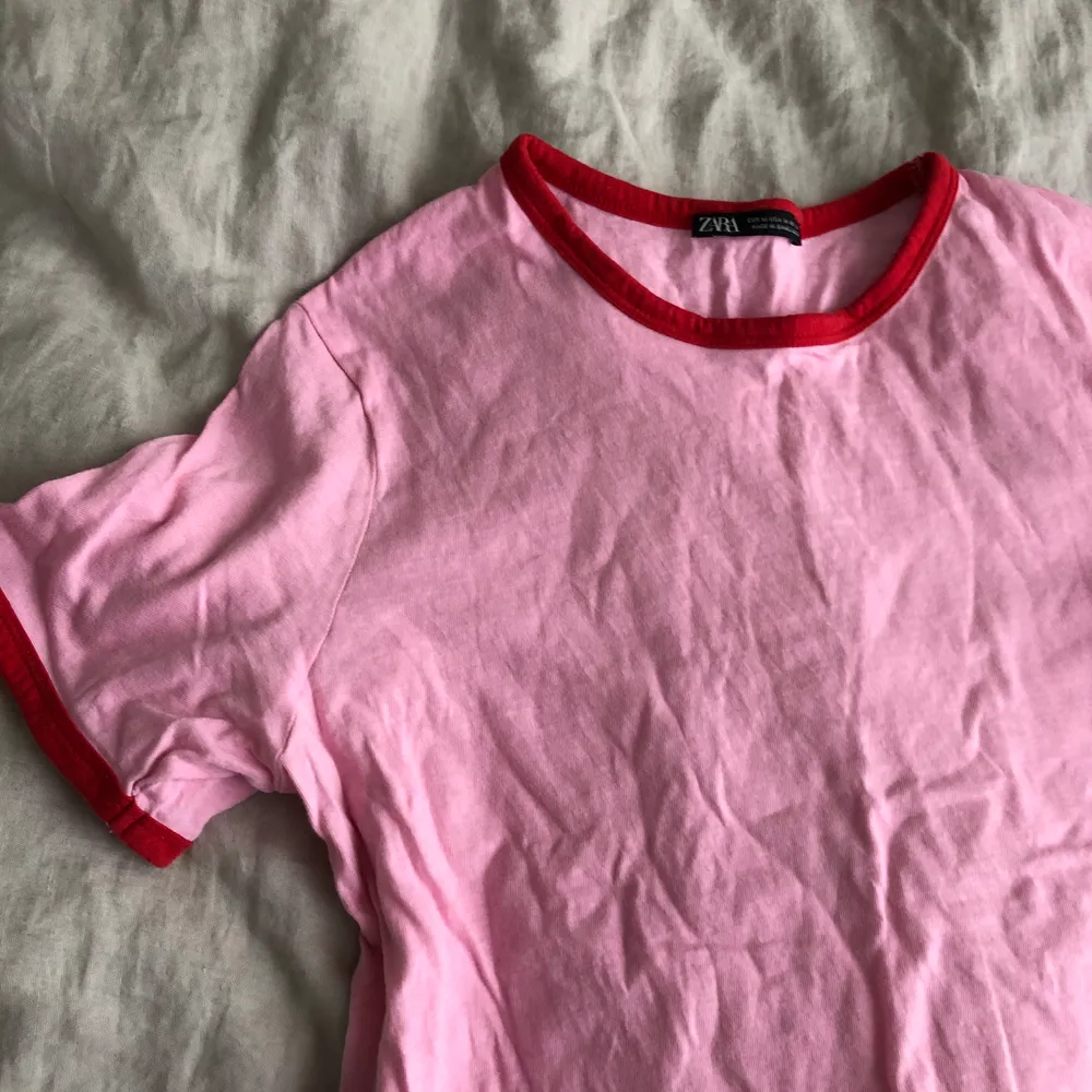 En rosa T-shirt från zara med röda detaljer, superfin passform och så fin kombo!. T-shirts.
