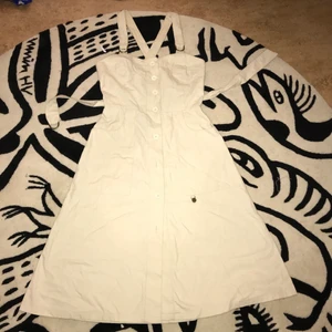 Klänning  - Krämvit retroklänning i jeans. Har x-rygg och band för midjan. En av mina absoluta favoritklänningar med den är dessvärre för liten. Köparen betalar frakt! Tar Swish 