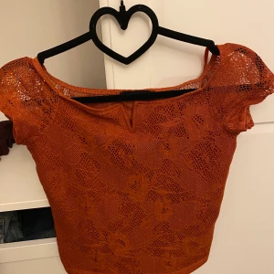 Rödaktig tajt tröja - Sälja pågrund då den inte används. Bara använts en gång och är i bra skick. Har genomskinlig spets där bak. Köptes i Italien. 