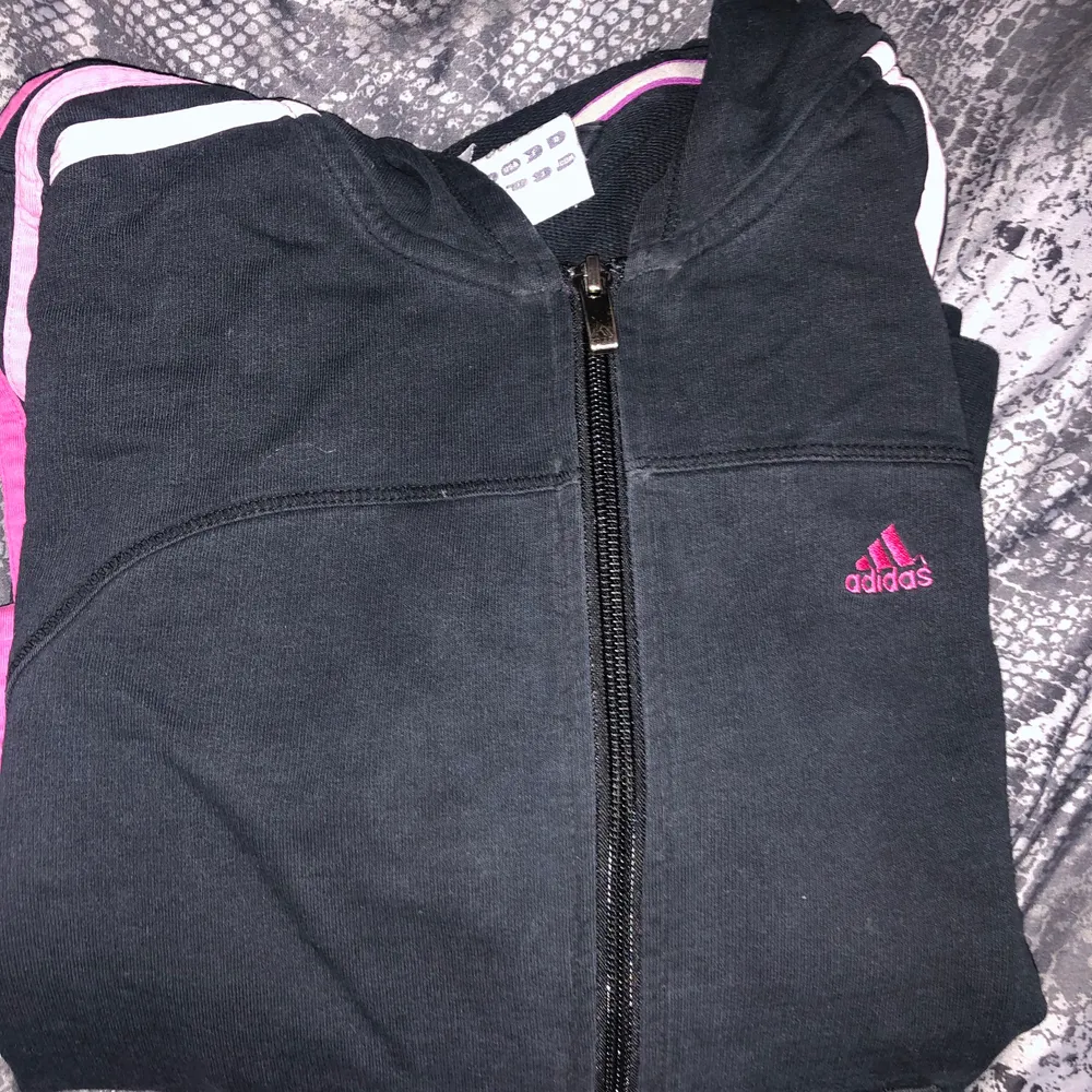 Svart adidaskofta med rosa tryck, motsvarar XS/S. Snygg för dig som vill ha en ”tajtare/kortare” look. Kan mötas upp eller fraktas, köpare står för frakt. Hoodies.