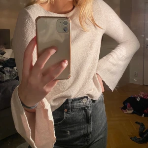 Långärmad tröja krämvit/beige - Säljer denna krämvita/beiga top med utåtsvängda armar. Perfekt nu till höst/vinter då den är i ett mjukt lite fluffigt material. 