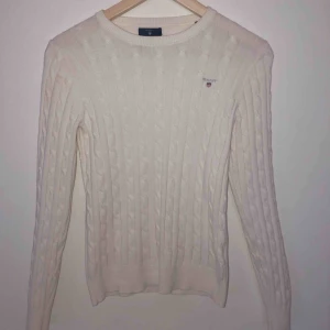 Gant tröja  - Detta är en ursnygg ribbstickad tröja som man kan ha över en  skjorta på en kall vinterdag eller på en varm dag matchad med en kjol.   Den sitter ganska tajt i modellen men materialet är väldigt stretchigt och passar de flesta kroppsformer . Pris kan dis.