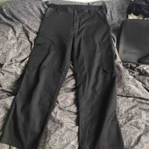  - ett par svarta arbetsbyxor med sidfickor, köpta second hand. 