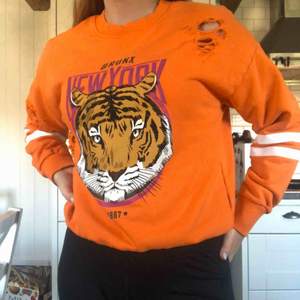 Orange tröja med en tiger på från Ginatricot. Frakt ingår i priset!!