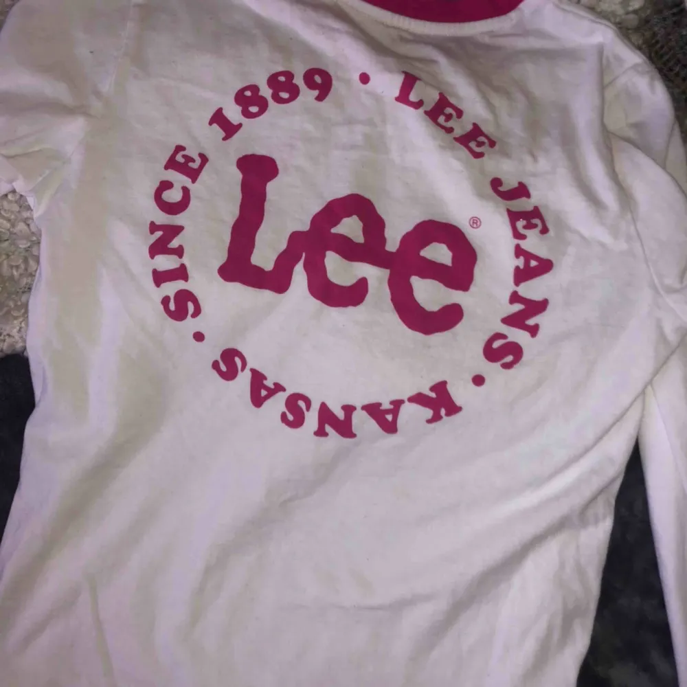 Långarmad vit Lee-tröja med rosa detaljer och ett coolt tryck! Använd endast en gång, därför säljer jag den :). Tröjor & Koftor.