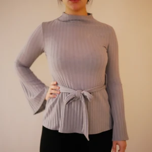  - En grå tröja från missguided med hög hals och band i midjan. Vida armar längst ner. Använd ca 1 gång så den är så gott som ny. 