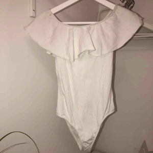  - Vit body med volang från Bershka. Använd ett fåtal gånger så i mycket fint skick. Köparen betalar frakten.
