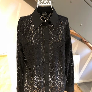 Ny spetsblus - Svart blus gjord i spets. Aldrig använd och har kvar prislappen. Små fickor på båda sidor. Köpt för 399 kr. Storlek 38.