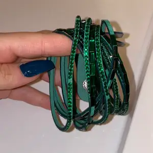 Jättefint armband i olivgrön, aldrig använt eftersom jag inte haft tillfälle man kan även använda det som halsband eftersom man snurrar runt armbandet 2 gånger runt handleden 