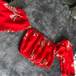 Röd, blommig topp. Storlek S passar M. - Ny topp, aldrig använd. Perfekt för sommaren. 🌞Passar både kjol och byxor. Topp är i storlek S men passar M också. Köparen står för frakten. 