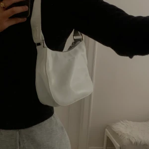 Trendig vit väska - En vit väska i baguette modellen. Kan frakta och mötas upp