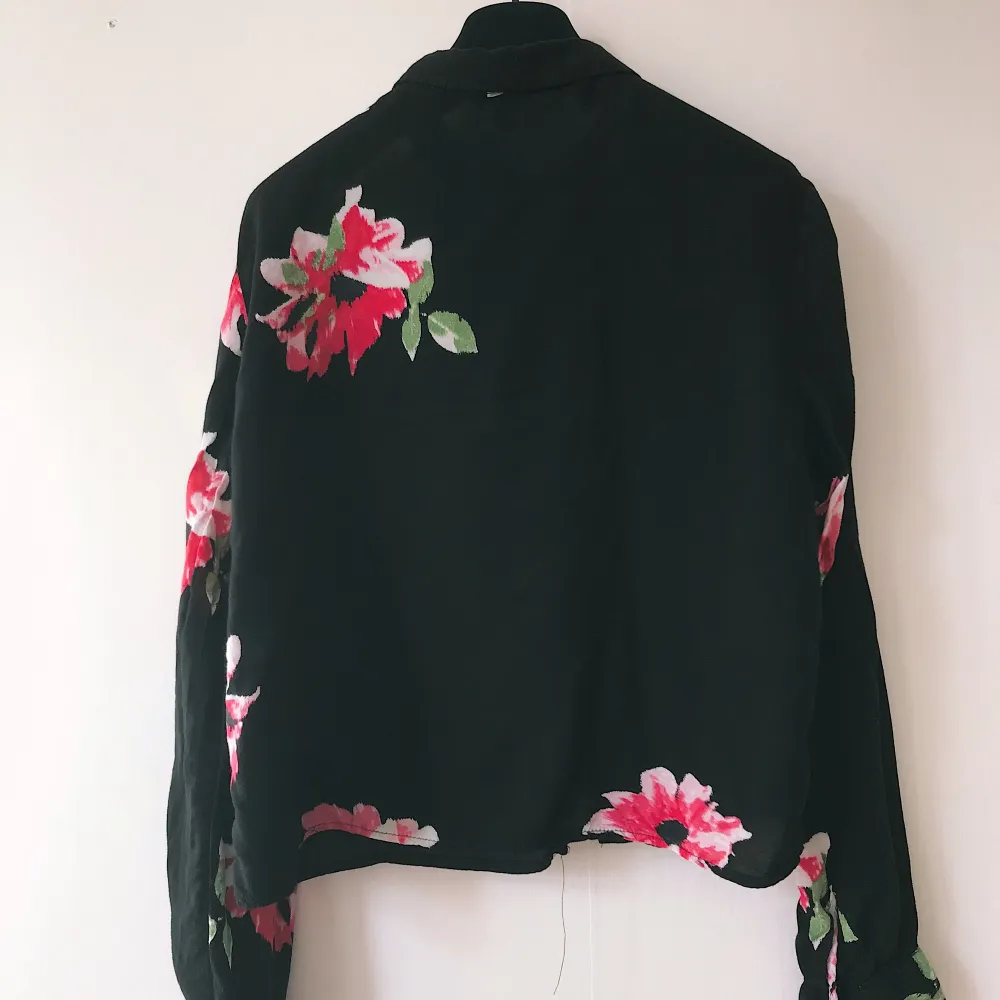 Long sleeved cropped shirt black woth pink flower print 🌸 from H&M, size 36, in very good conditions. Blusar.