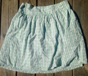 Grönvit-rutig kjol. Midjemåttet är 73 cm. 