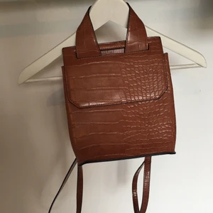 Asos Ryggsäck, läderimitation - En mindre ryggsäck från asos i mycket bra skick med fack inuti, läderimitation.                                                            Möts upp i Sthlm annars står köparen för frakt.