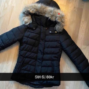  - Svart jacka med fake päls på luvan, knappt använd. 