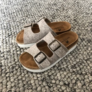 Shepherd of Sweden sandaler - Patricia platåsandaler från Shepherd of Sweden med remmar i filtad ull och spännen i metall. Mycket sköna! Endast använda ett fåtal gånger. En skavank på sulan på höger sandal under stortån (ses på bild 3). 