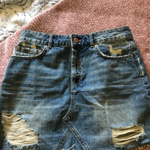 Kjol från zara strl M - Denna jeans kjol är från zara och är i storlek M. Slitningarna på framsidan gör kjolen snyggare.