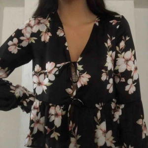  - Blommig blus från bikbok 💘Tyget är lite glansigt och den knyts framtill. Frakt på 50kr tillkommer