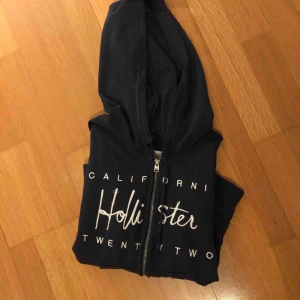  - En mörkblå hollister kofta.