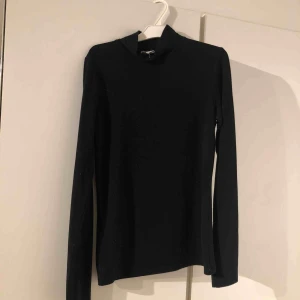  - En svart polotröja.