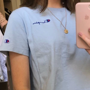 T-shirt från champion - En superfin babyblå lite kortare t-shirt från champion. Storlek S. Se färg bäst på bild 1. Har inte fått användning för denna :(