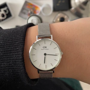 Silvrig Daniel Wellington klocka  - Säljer min Daniel Wellington klocka. Den har tre små repor (bild2). Men syns inte om man inte tittar supernoga. I övrigt är den i bra skick. Nypris 1299kr