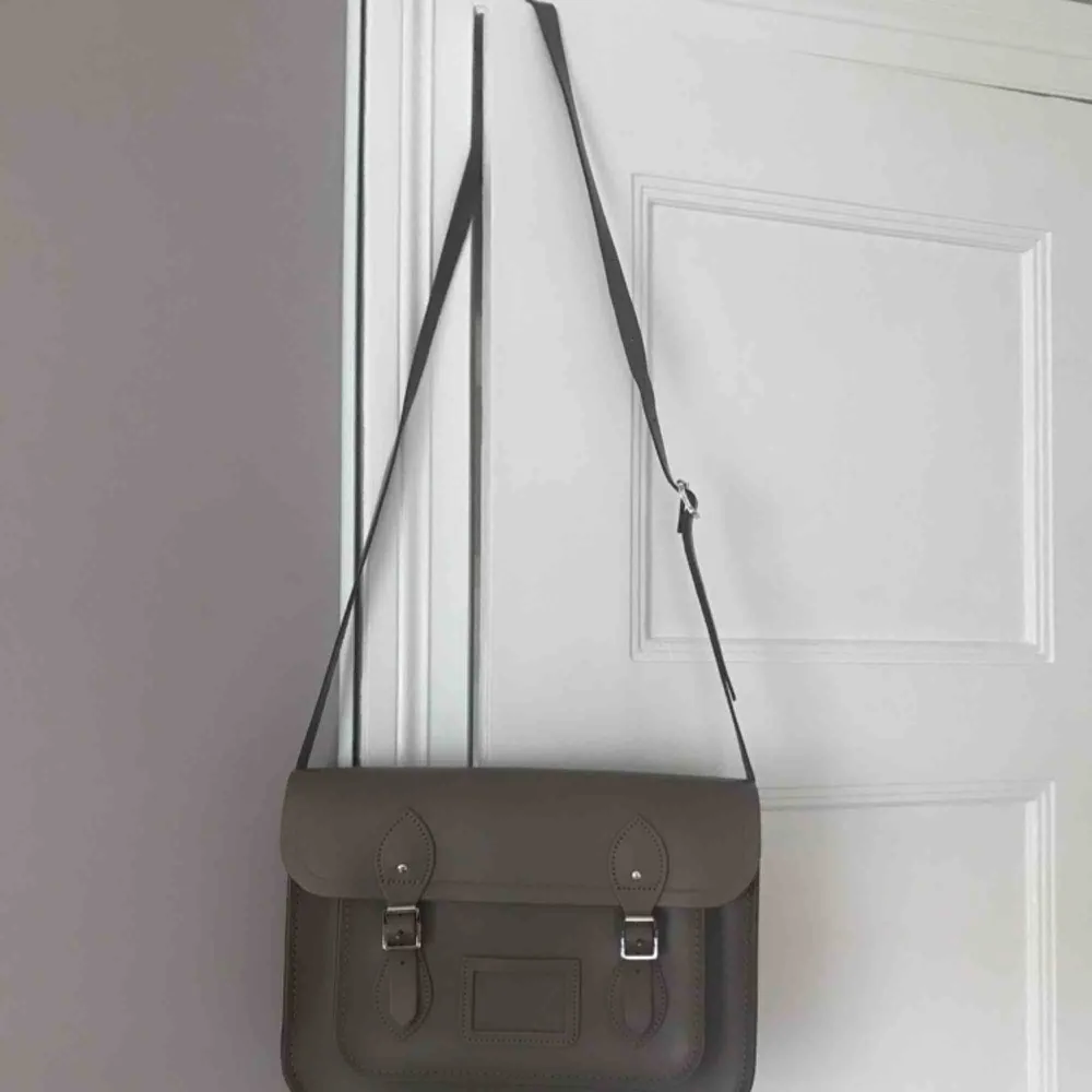 13 inch väska från ”The Cambridge satchel company”. Köpt för 2000 kr och har blivit använd ungefär 2 gånger. Mörkbrun i äkta läder och silverspännen. Frakt ingår. Pris kan diskuteras :) . Väskor.