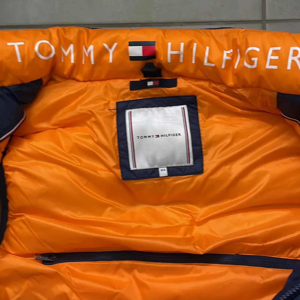 Mörkblå väst från Tommy Hilfiger, storlek 164. Använd ett fåtal gånger, mycket fint skick. Frakten är inkluderad.. Jackor.