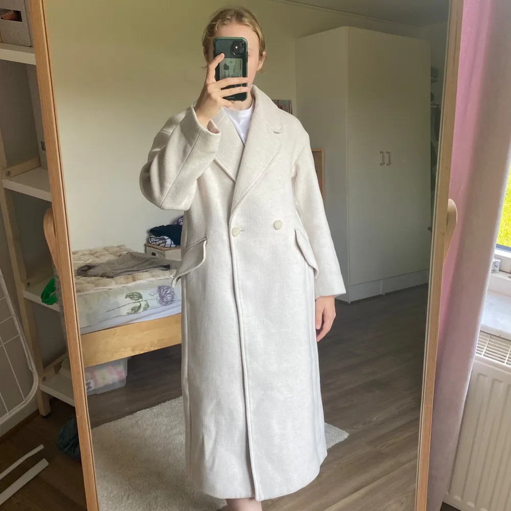 Beige kappa från H&M. De två sista bilderna visar färgen bäst. Fint skick. Lite nopprig på vissa ställen, men jag har använt noppborttagare så det är knappt märkbart. Den har ett märke (bild 4), men det döljs om man stänger kappan & är ganska diskret. Takit.
