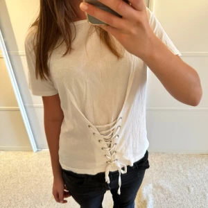 Vit t-shirt med knytning i midjan - Strl L men passar mer som en M skulle jag säga💖 I bra skick! Köp gärna genom köp nu💕