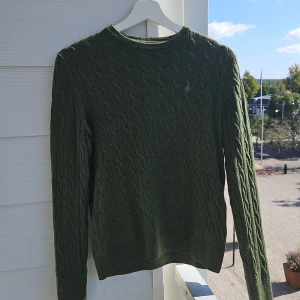 Tröja Morris - Olivgrön merinotröja från Morris. Tröjan är använd men i fint skick.   Lappen i nacken har släppt på ena sidan, se bild