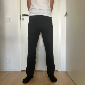 Only&sons jeans, Edge Loose 29/34 - Svarta jeans, Only&Sons. Stl 29/34. Det är två vikveck längst ner (se bild 4). Jeansen  är uppvikta på bild 1 och 2, då syns inte vecken. De sitter bättre uppvikta på mig som är 183cm lång. Bild 5, två små trådar, svåra att fånga på bild. 