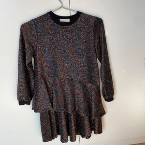 Glittrig Volangklänning - Glittrig klänning från minimarket i fint skick.