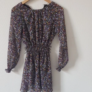 Blommig klänning - Långärmad, lätt, kort Har aldrig använt, inte min stil.