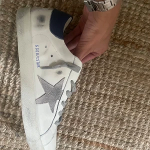 Sneakers med stjärnor - Hej jag säljer dessa snygga vita sneakers som har grå stjärnor och snören på sig. De är enbart använda ett par gånger och är i mycket bra skick. De är i storlek 44 men är ganska små i storleken o sitter ungefär som ett par normala 43or.