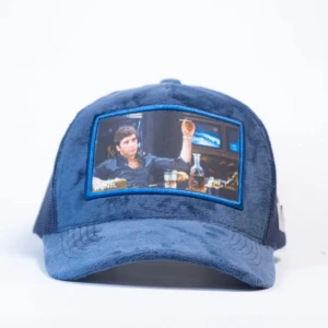 Blå keps med tryck från Wonti - Snygg blå keps från Wonti med ett coolt tryck på framsidan. Kepsen har en mesh-baksida för bra ventilation och en böjd skärm. Perfekt för att ge din outfit en avslappnad och trendig look!