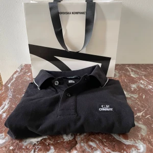 C.P company piké  - Helt ny skick! Det är en CP company piké som är köpt på NK. Det är storlek S och är regular fit. Skicket är 10/10 nästan aldrig använd. Ny pris 1500kr. (På bild 2 ser pikén nästan lite solblekt ut men den är inte det, så ser det endast ut på bilden.