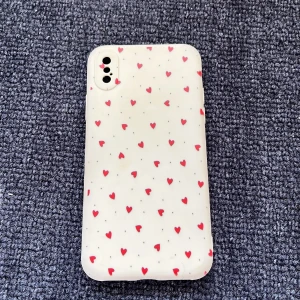 IPhone X/XS skal  - Ett iphone skal med röda hjärtan och svarta prickar på. Beige/ljusrosa bakgrund. Använd ett fåtal gånger.  Material: Silikon 
