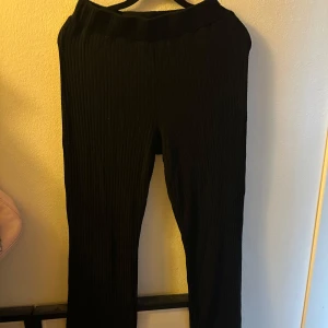 Svarta ribbade byxor - Snygga svarta ribbade byxor med hög midja. Perfekta för en stilren look och bekväma att bära hela dagen. Passar bra till både vardag och mer uppklädda tillfällen.