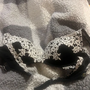 Intimissimi bh  - Elegant svart bh med vit spetsdetaljering. Axelbanden e omsydda. Skriv för mer bilder på de. Passar en smalare cupa 