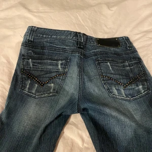 Blå jeans från River Island - Snygga blå jeans från River Island med slitna detaljer, fina bakfickor och mer lågmidjadr än va de ser ut. Säljer pga att de inte passar längre. Midjemått: 37 cm(rakt över) Innerbenslängd: 71 cm Ytterbendlängd: 93 cm 💕